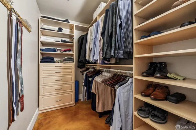 a view of walk in closet with clothes and shoes