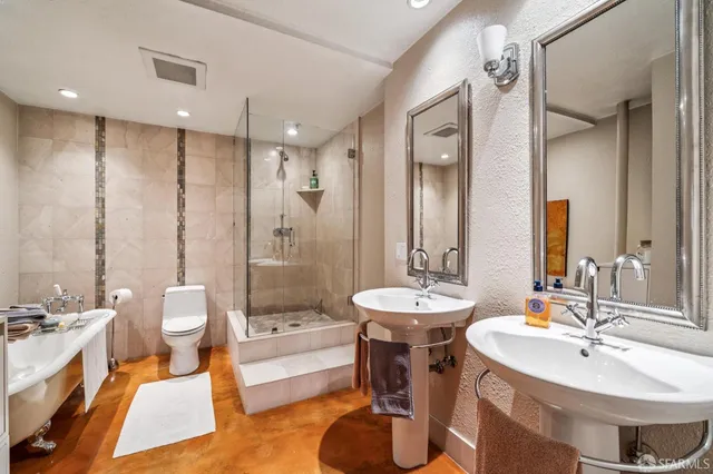 a bathroom with a double vanity sink toilet and shower