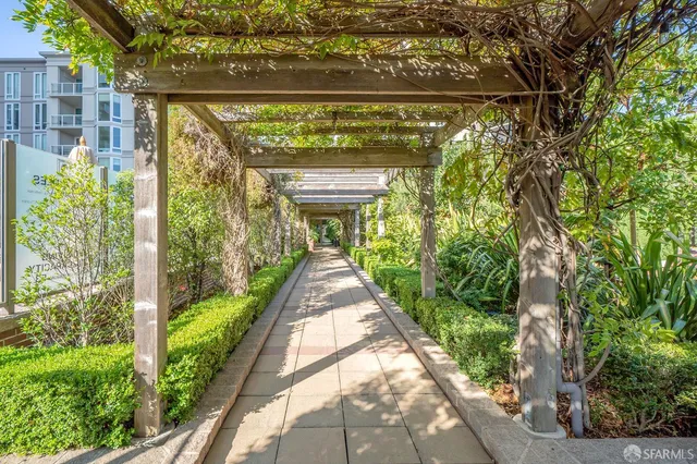 a view of a pathway of a building with a fountain in the background