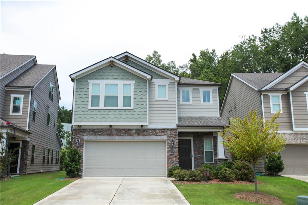 a front view of a house with a garden and plants