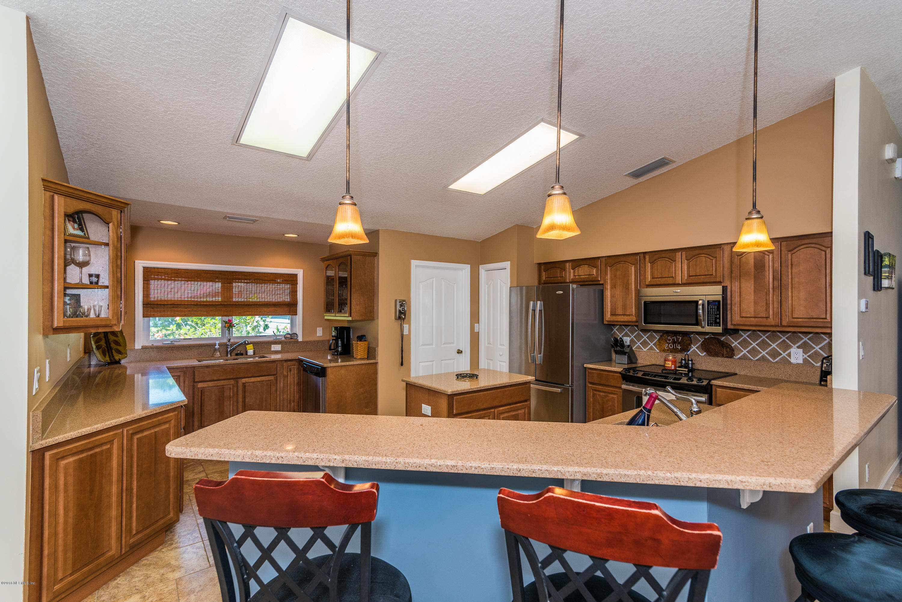 707 Warbler Road St. Augustine, FL 32086 - Photo 6 of 37 a room with stainless steel appliances kitchen island granite countertop dining table chairs and a wooden floor