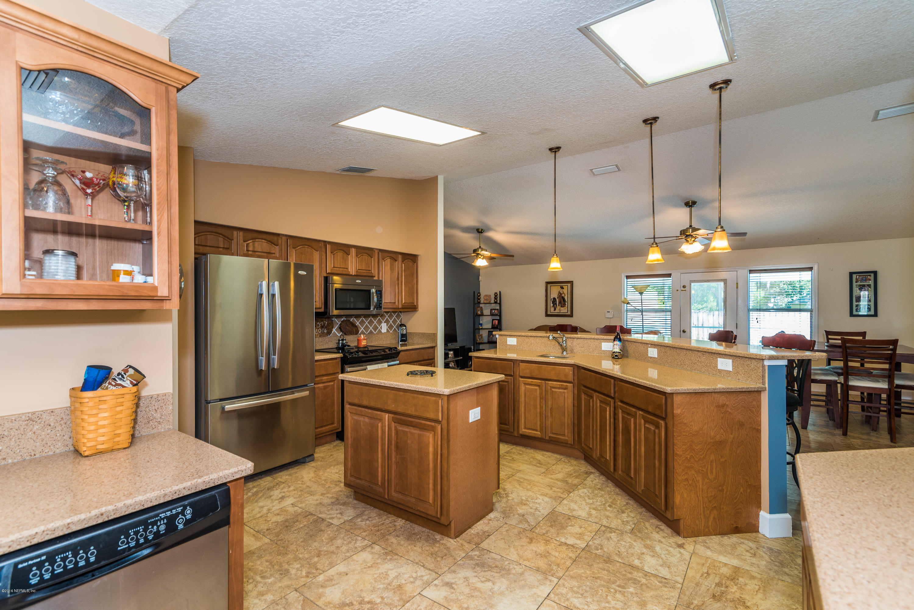 707 Warbler Road St. Augustine, FL 32086 - Photo 10 of 37 a kitchen with stainless steel appliances granite countertop a refrigerator a sink dishwasher a dining table and chairs with wooden floor
