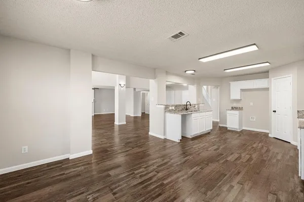a view of kitchen with kitchen island wooden cabinets and refrigerator