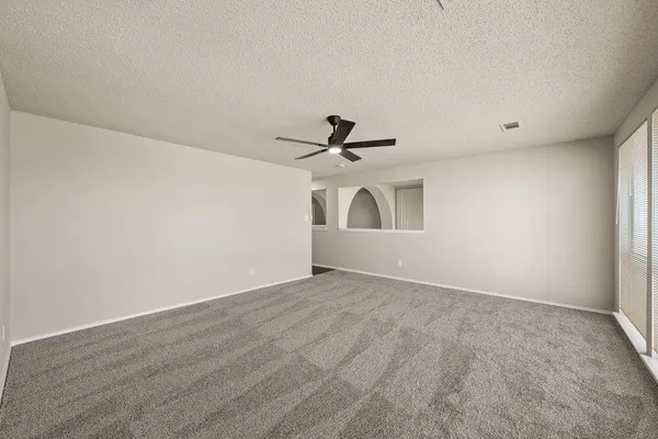 a view of empty room with ceiling fan