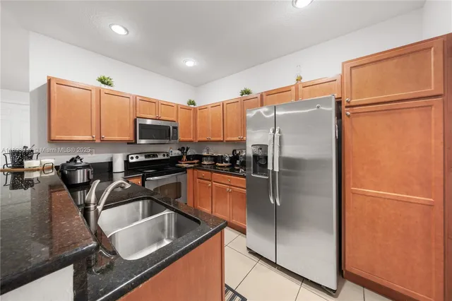a kitchen with granite countertop a refrigerator and a sink