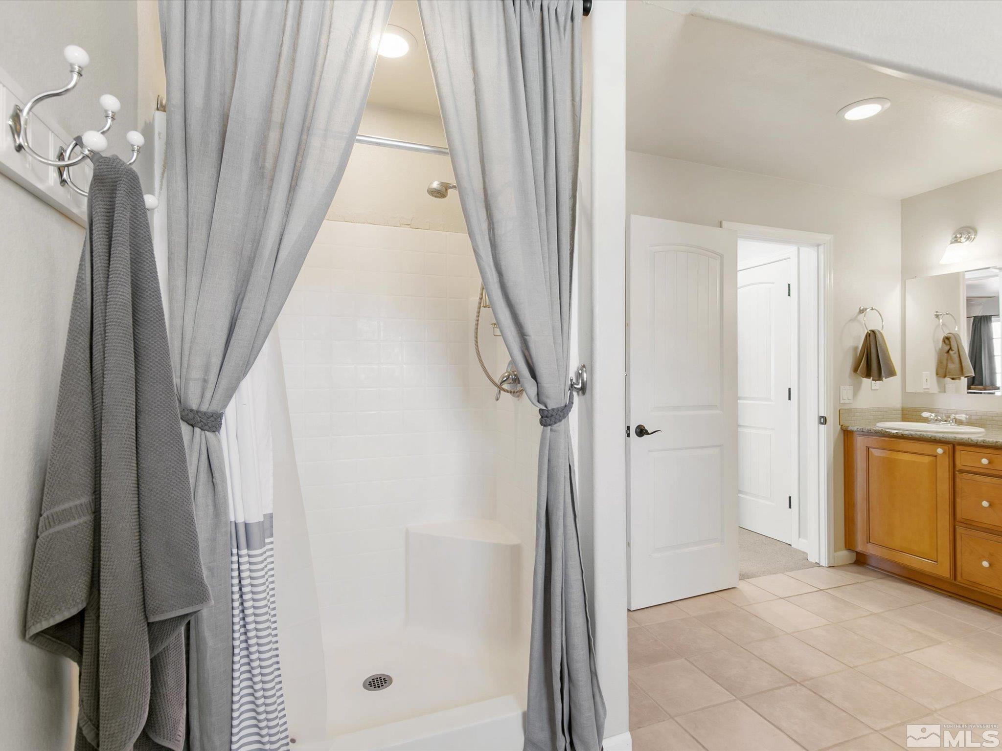 6900 Grass Valley Road Reno, NV 89510 - Photo 26 of 42 a bathroom with a granite countertop sink a mirror and a shower