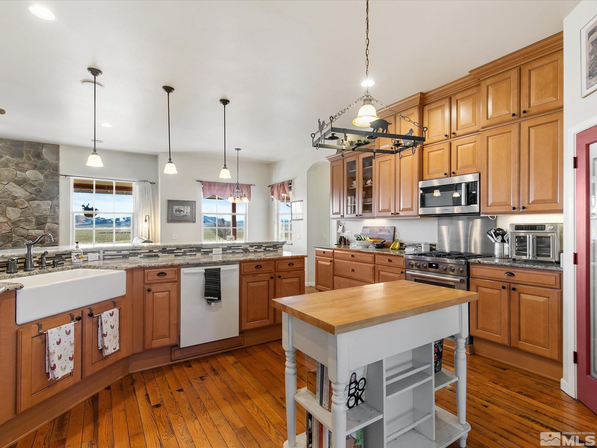 6900 Grass Valley Road Reno, NV 89510 - Photo 8 of 42 a kitchen with granite countertop a stove top oven a sink dishwasher a dining table and chairs with wooden floor