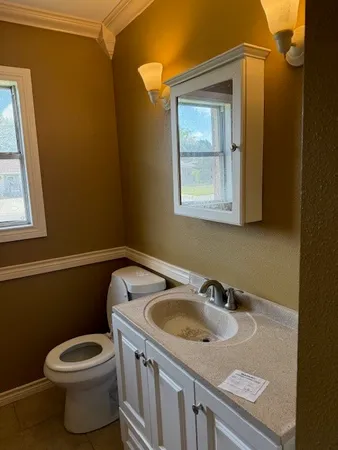 a bathroom with a sink toilet and window