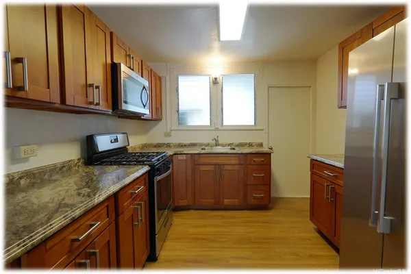 a kitchen with stainless steel appliances granite countertop a sink stove and refrigerator