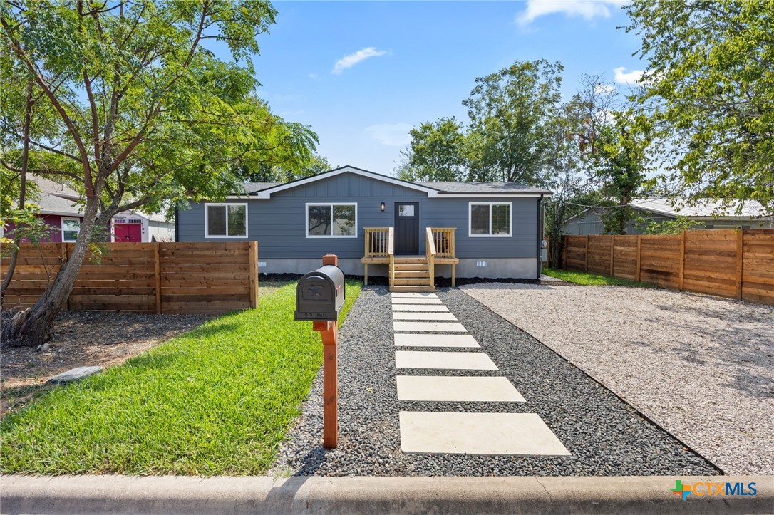 a front view of a house with a yard and trees