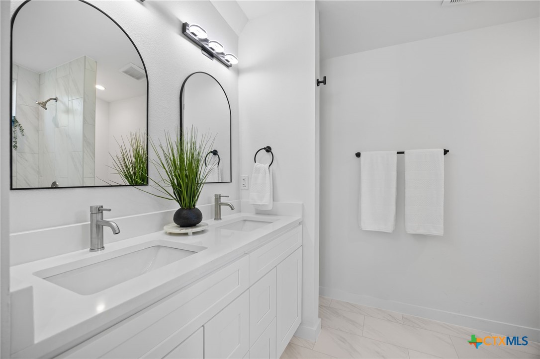 404 East Pecan Street Taylor, TX 76574 - Photo 12 of 19 a bathroom with a sink and a mirror