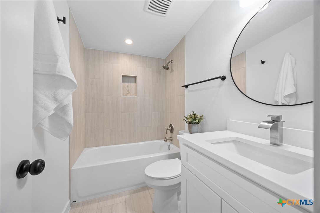 404 East Pecan Street Taylor, TX 76574 - Photo 15 of 19 a bathroom with a sink a toilet and a mirror