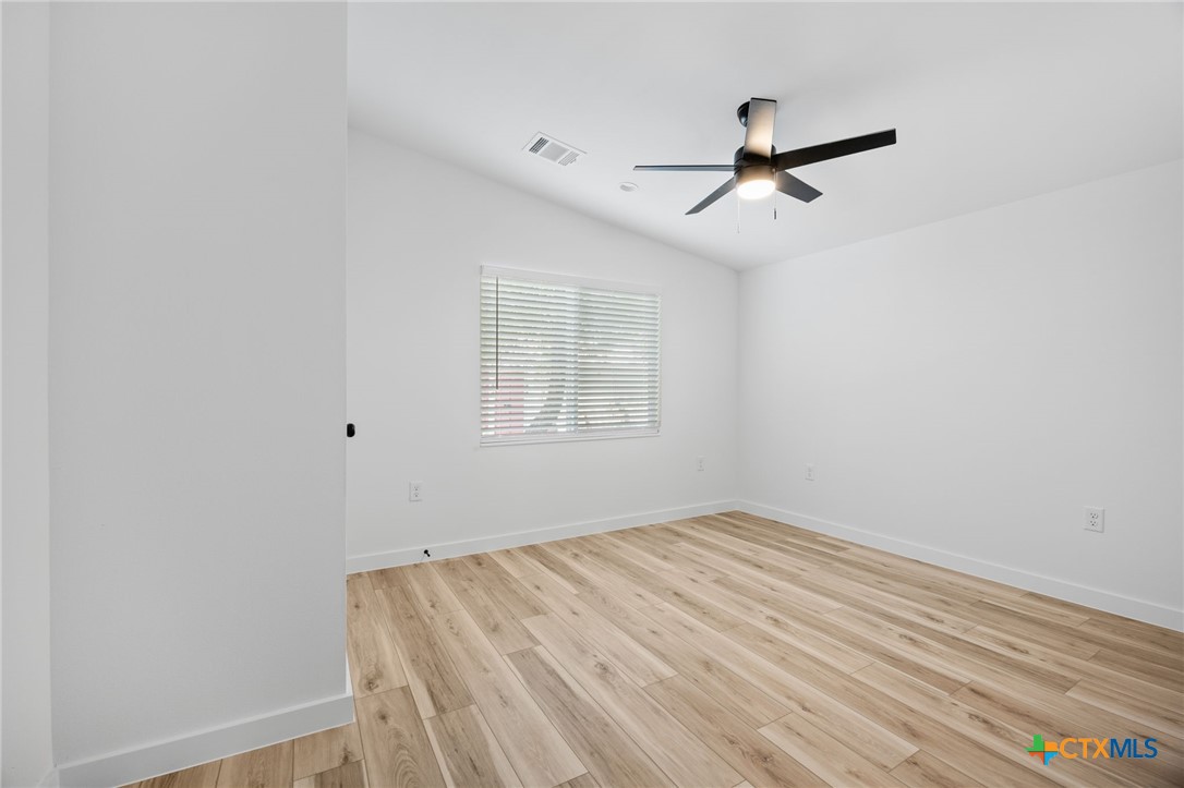 404 East Pecan Street Taylor, TX 76574 - Photo 16 of 19 an empty room with a window and ceiling fan