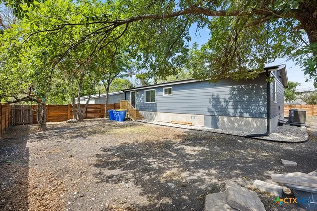a backyard of a house with barbeque oven table and chairs