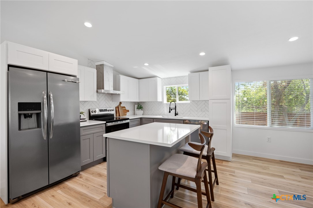 404 East Pecan Street Taylor, TX 76574 - Photo 7 of 19 a kitchen with kitchen island a counter top space cabinets and stainless steel appliances