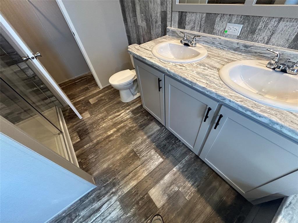 318 Seminole Quitman, TX 75783 - Photo 26 of 36 a bathroom with a granite countertop sink a toilet and a mirror