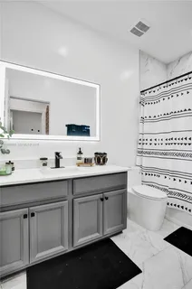 a bathroom with a sink a toilet and a mirror