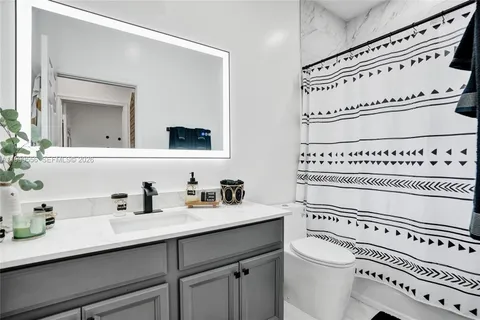 a bathroom with a sink a toilet and a mirror