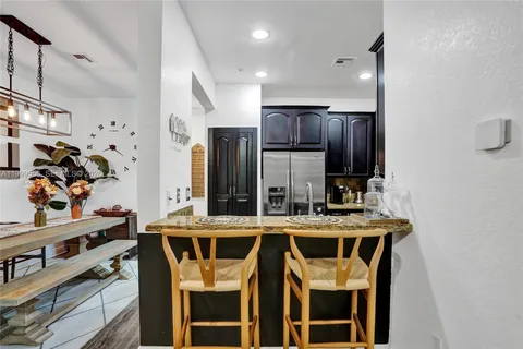 a kitchen with granite countertop a stove top oven microwave and cabinets