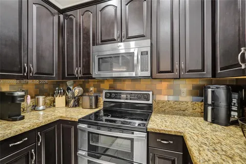 a kitchen with stainless steel appliances granite countertop a refrigerator and a stove