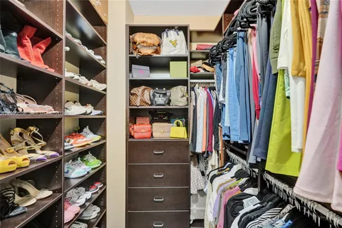 a view of walk in closet with clothes and shoes