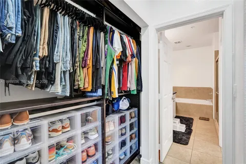 a view of walk in closet with clothes and shoes