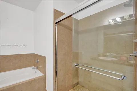 a bathroom with a tub double sink and mirror