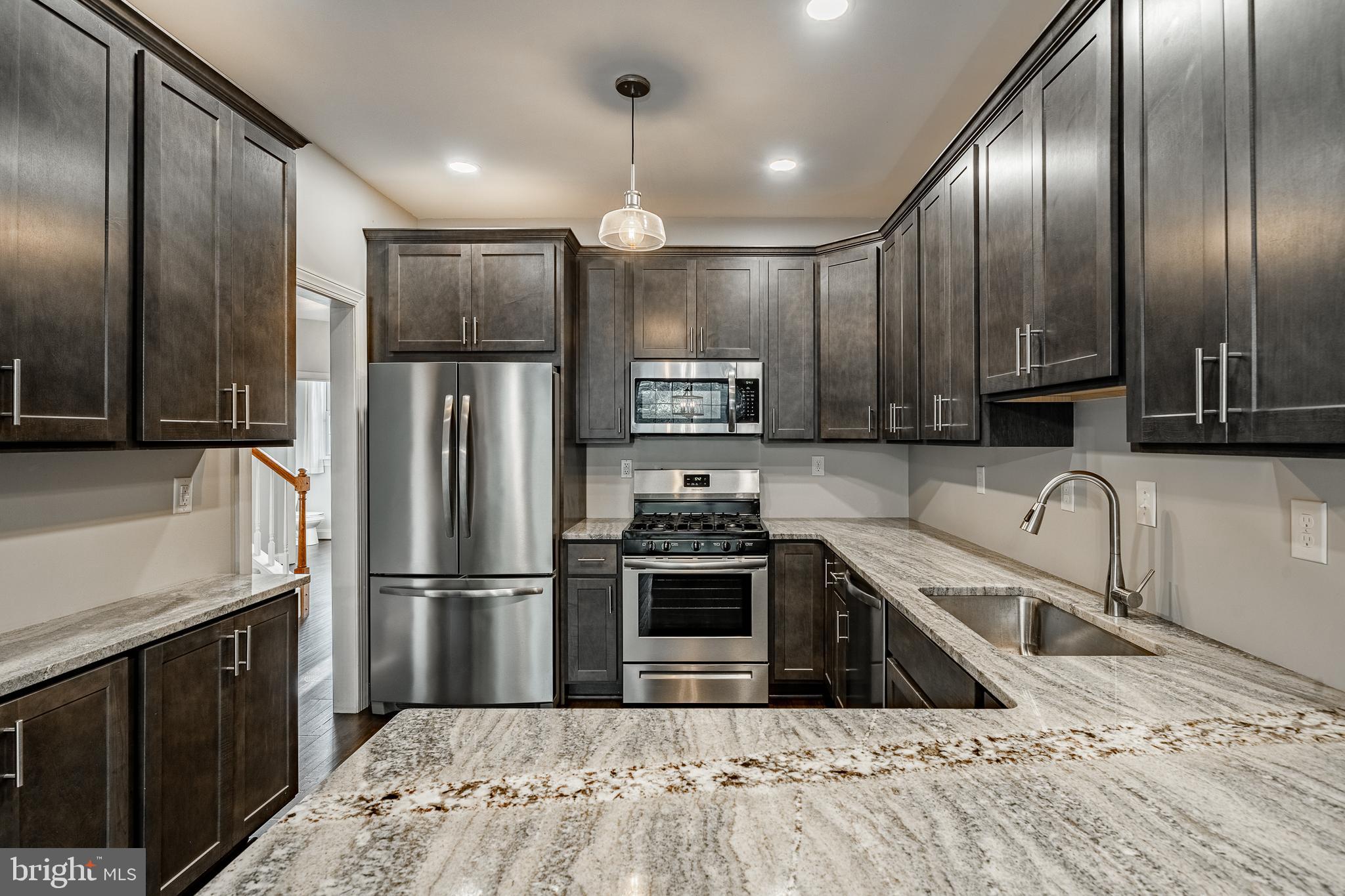 112 Federal Walk Kennett Square, PA 19348 - Photo 3 of 54 a kitchen with granite countertop a refrigerator a sink a stove and cabinets