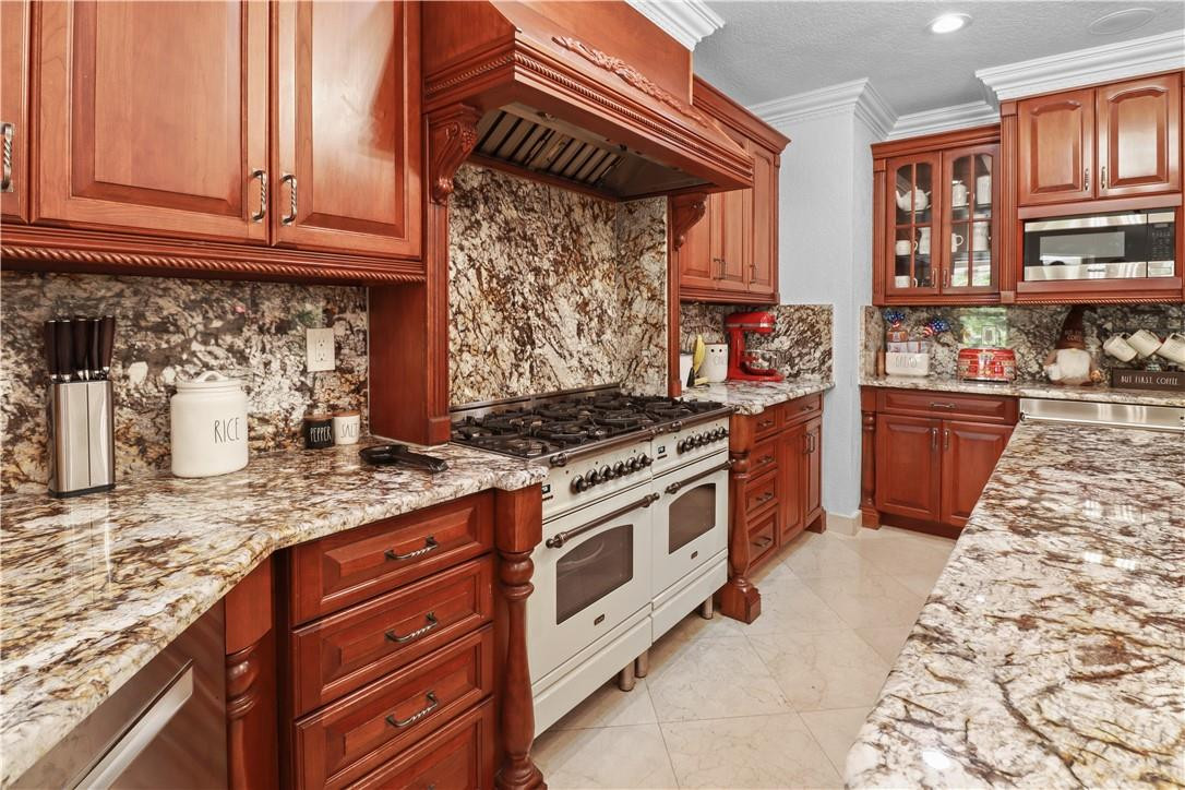 14540 Southwest 63rd Street Southwest Ranches, FL 33330 - Photo 28 of 69 a kitchen with stainless steel appliances granite countertop a stove and a sink