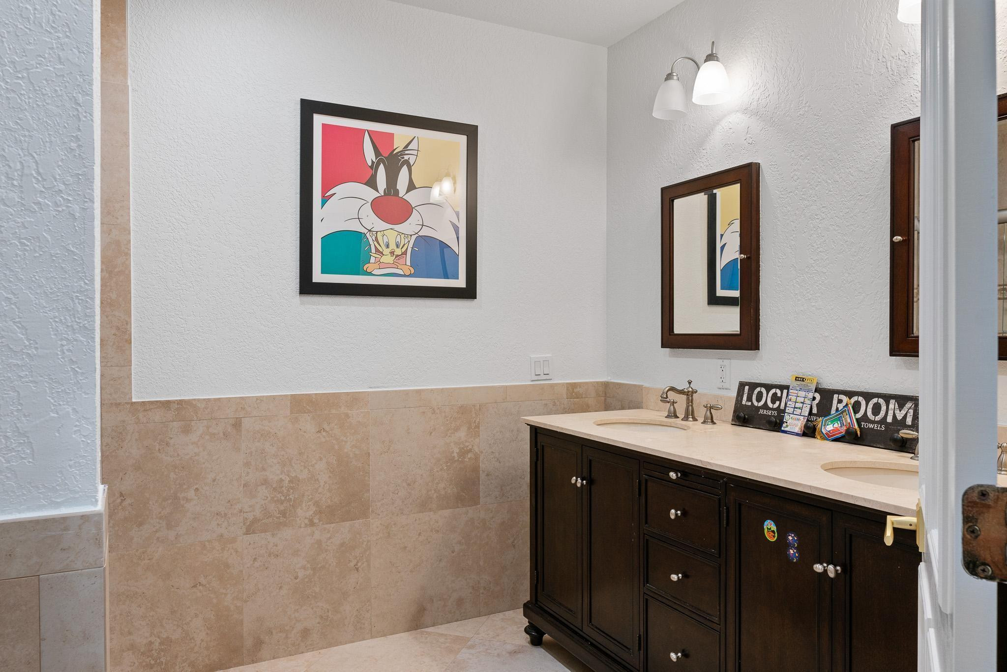 14540 Southwest 63rd Street Southwest Ranches, FL 33330 - Photo 54 of 69 a bathroom with a double vanity sink and a mirror