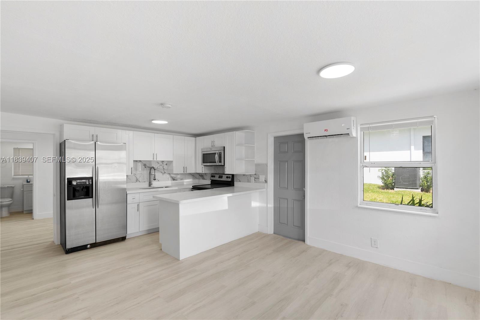 607 Southwest 3rd Street, Unit 1 Delray Beach, FL 33444 - Photo 11 of 27 a kitchen with stainless steel appliances a refrigerator sink and stove