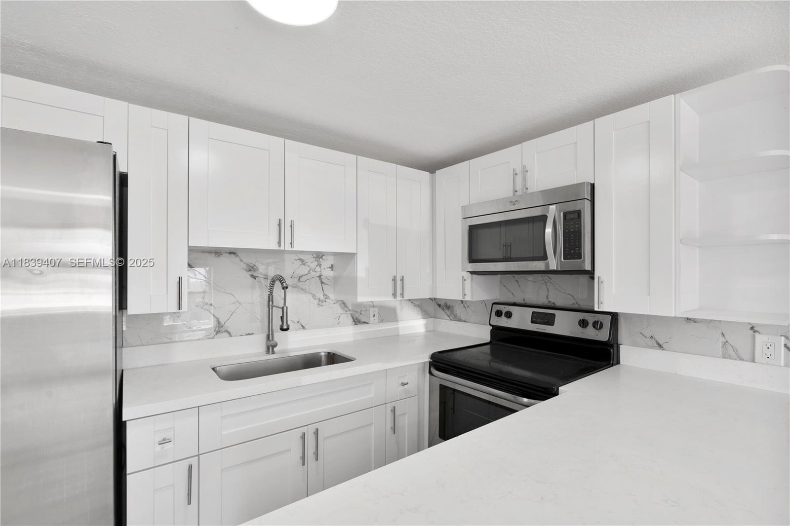 607 Southwest 3rd Street, Unit 1 Delray Beach, FL 33444 - Photo 13 of 27 a kitchen with appliances a sink and cabinets