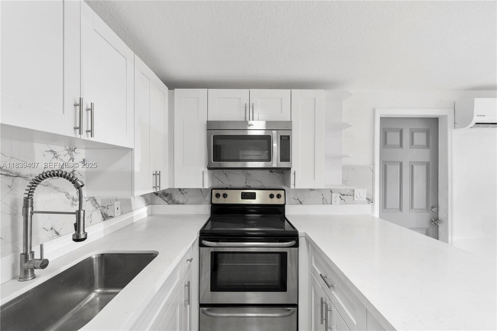 607 Southwest 3rd Street, Unit 1 Delray Beach, FL 33444 - Photo 14 of 27 a kitchen with granite countertop a stove and a sink