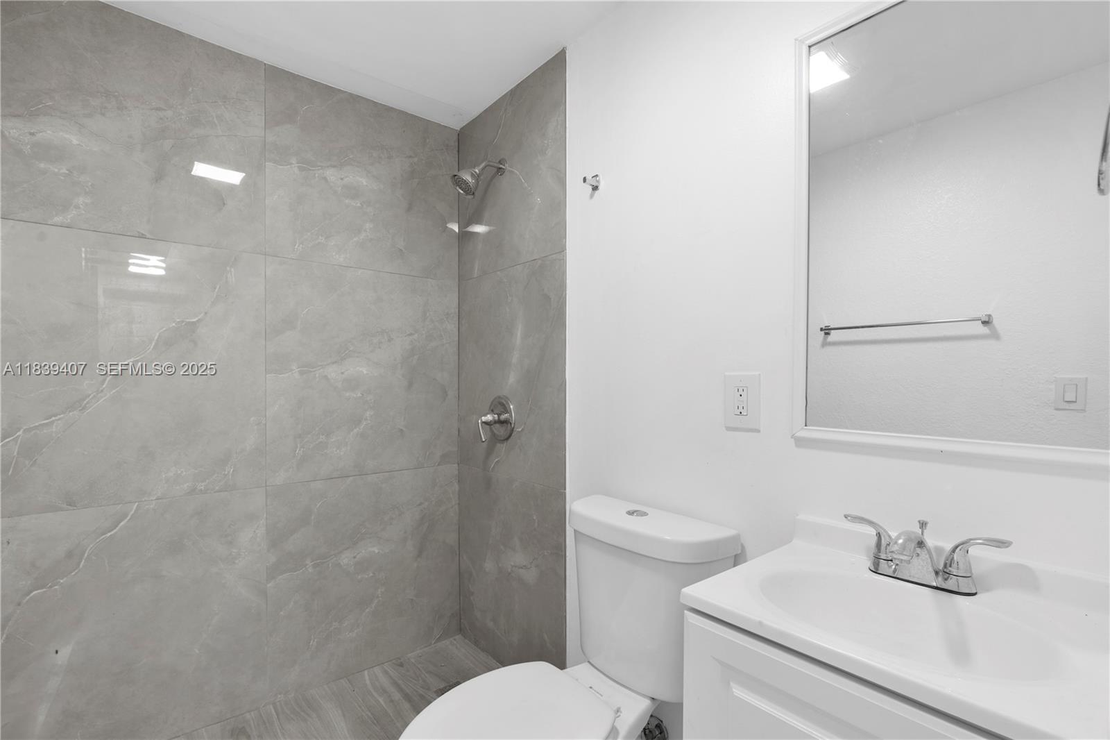 607 Southwest 3rd Street, Unit 1 Delray Beach, FL 33444 - Photo 22 of 27 a bathroom with a sink toilet and a mirror