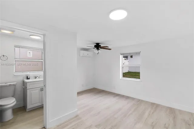 a bathroom with a granite countertop toilet and a sink