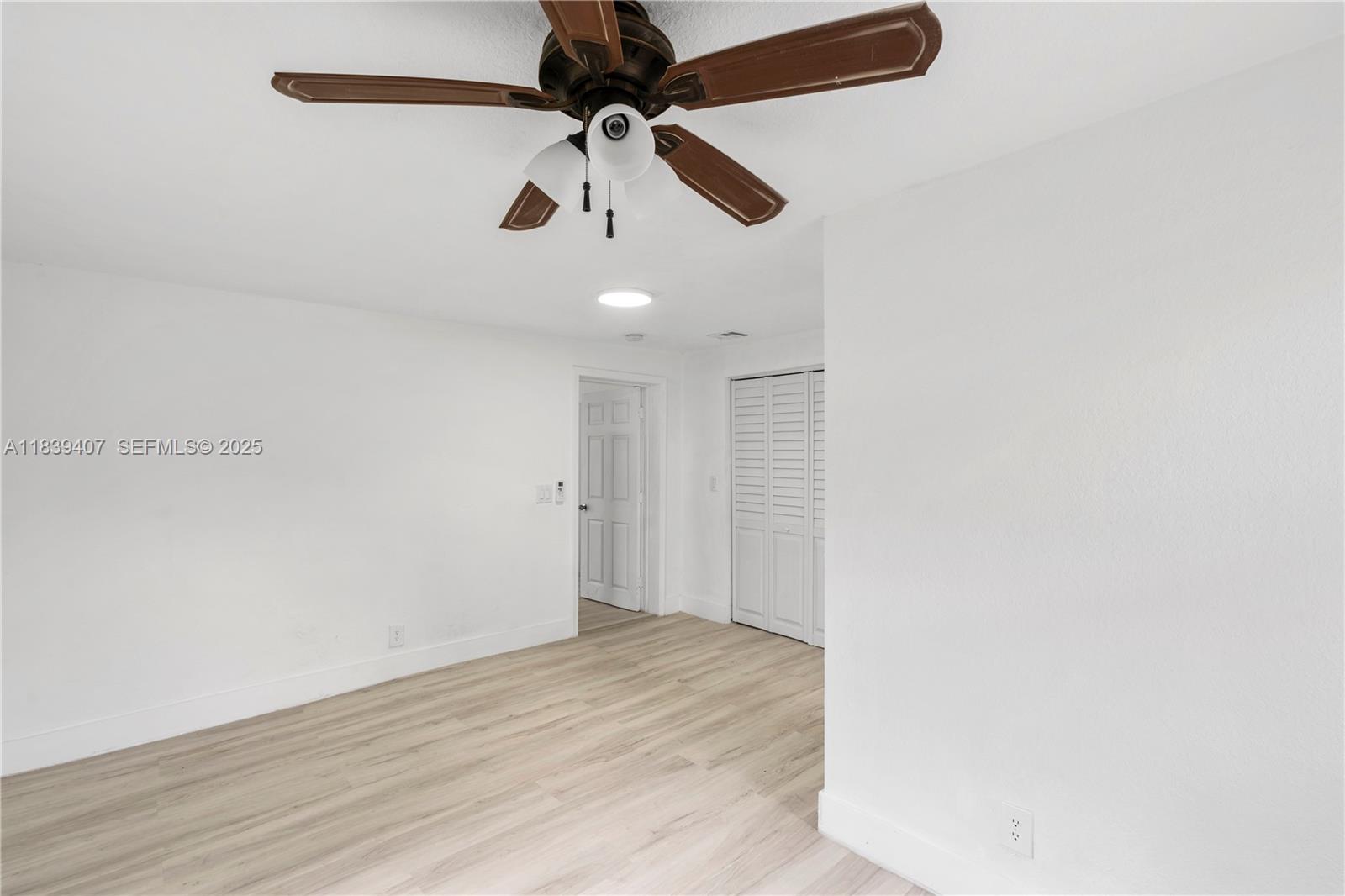 607 Southwest 3rd Street, Unit 1 Delray Beach, FL 33444 - Photo 25 of 27 an empty room with a ceiling fan and wooden floor