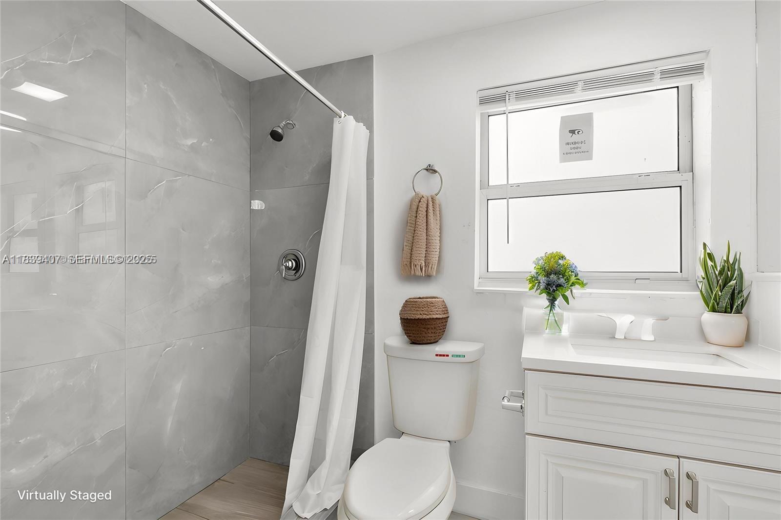 607 Southwest 3rd Street, Unit 1 Delray Beach, FL 33444 - Photo 6 of 27 a bathroom with a toilet a sink and a shower