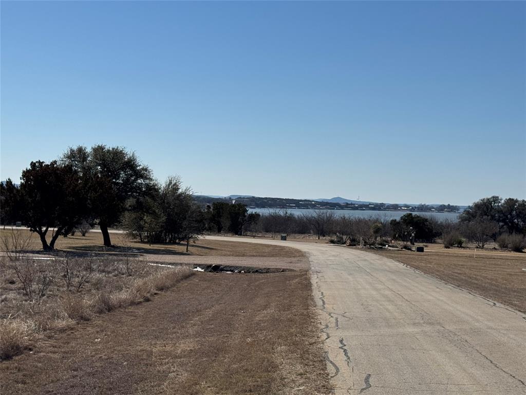 Lot 1049 Frog Branch Graford, TX 76449 - Photo 2 of 14 a view of a dry yard with wooden fence
