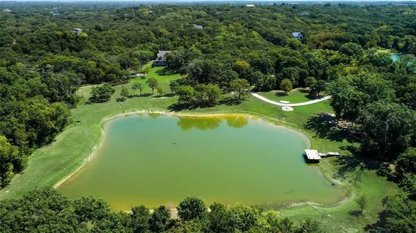 an aerial view of a house with a yard and lake view