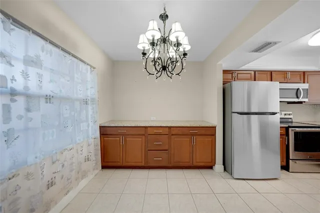 a kitchen with stainless steel appliances granite countertop a refrigerator a oven and a sink
