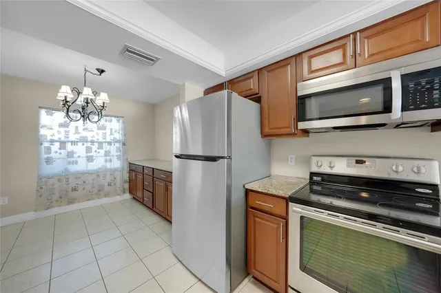 a kitchen with stainless steel appliances granite countertop a refrigerator and a stove top oven