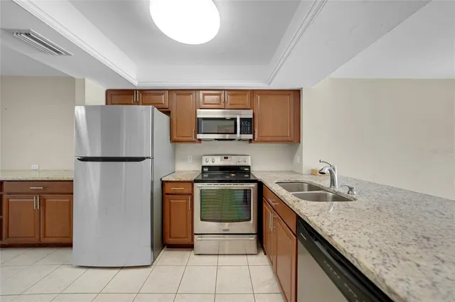 a kitchen with stainless steel appliances granite countertop a refrigerator stove a sink and a microwave