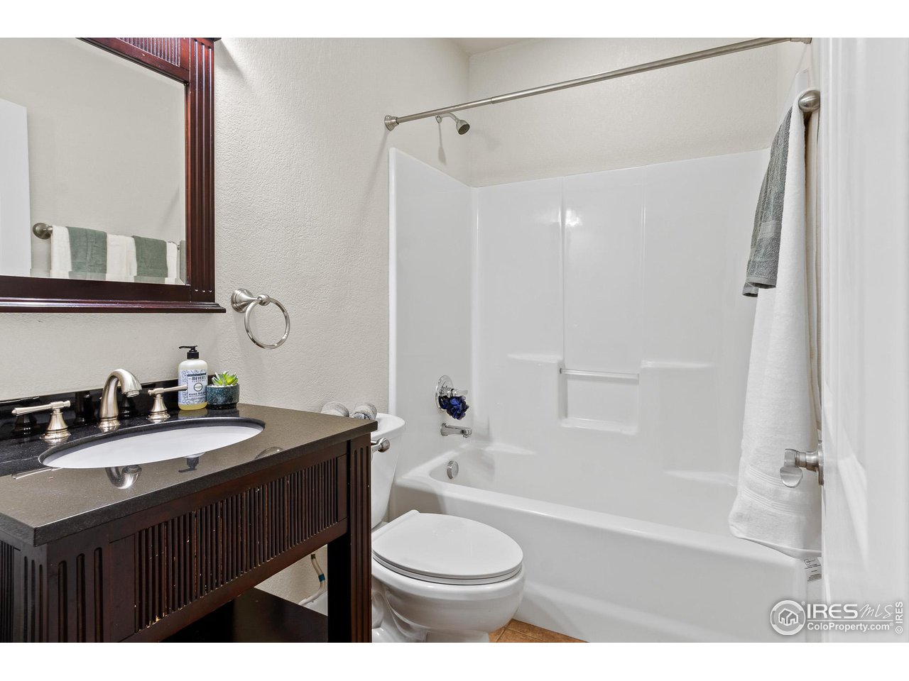 2002 Trail Ridge Drive Severance, CO 80615 - Photo 17 of 38 a bathroom with a sink a toilet a mirror a bathtub and shower