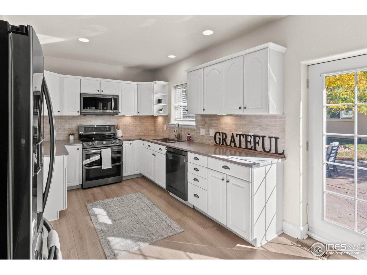 2002 Trail Ridge Drive Severance, CO 80615 - Photo 9 of 38 a kitchen with granite countertop white cabinets and stainless steel appliances
