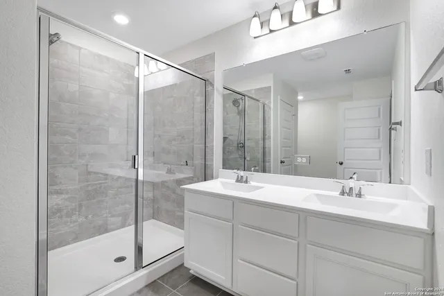a bathroom with a shower sink and mirror