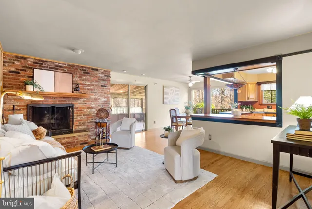 a living room with fireplace furniture and a large window