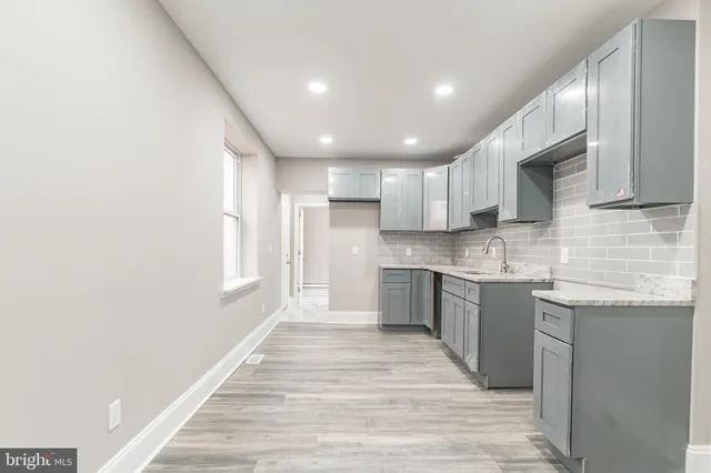 a large kitchen with stainless steel appliances granite countertop a sink and cabinets
