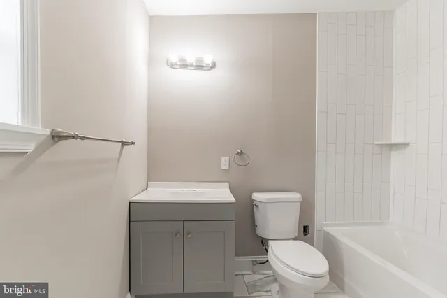 a white toilet sitting next to a bath tub