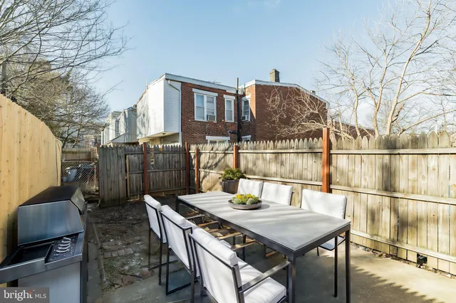 a backyard of a house with table and chairs