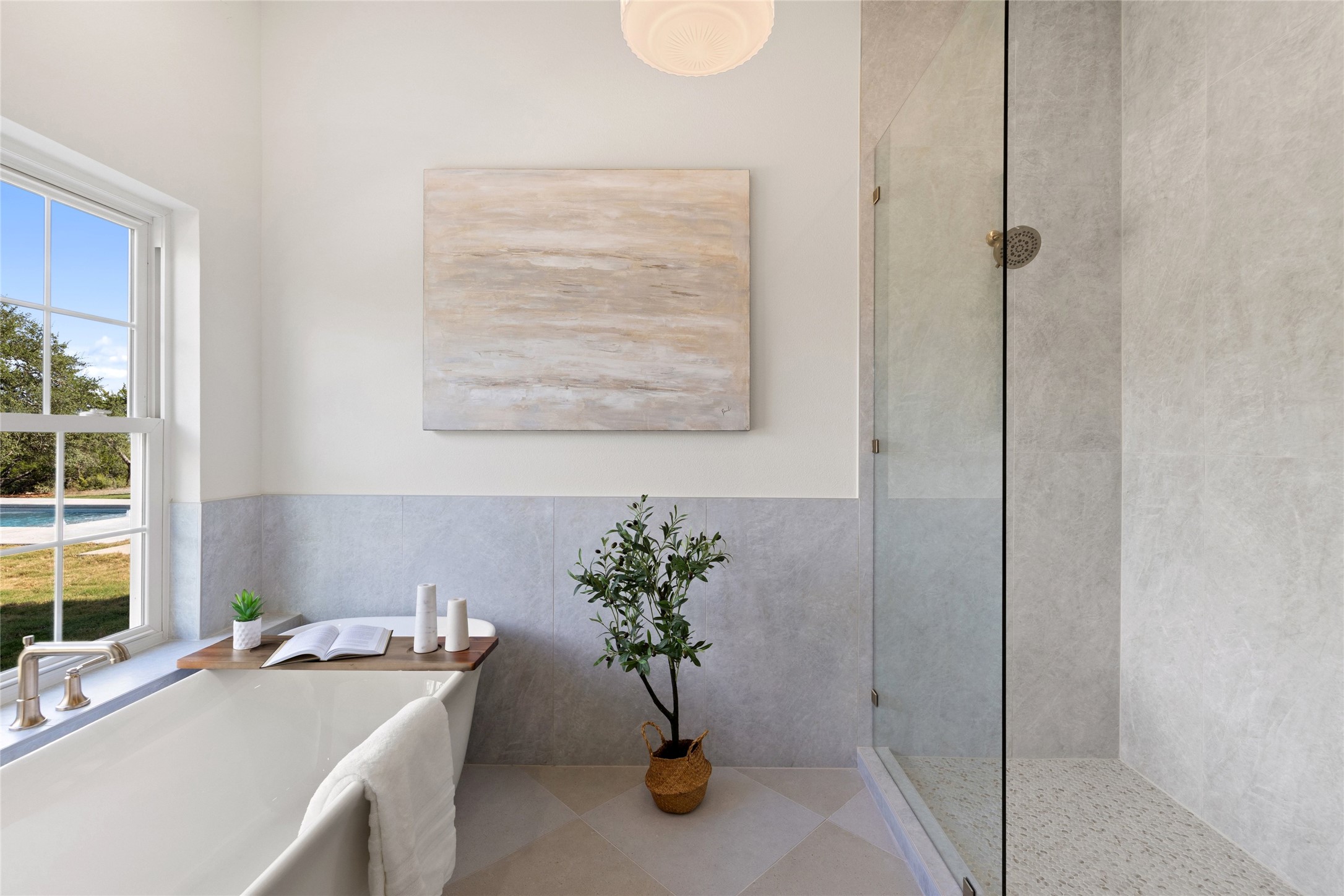 601 Hays Country Acres Road Dripping Springs, TX 78620 - Photo 20 of 38 A glass-enclosed shower and standalone soaking tub define this modern, light-filled bathroom.
